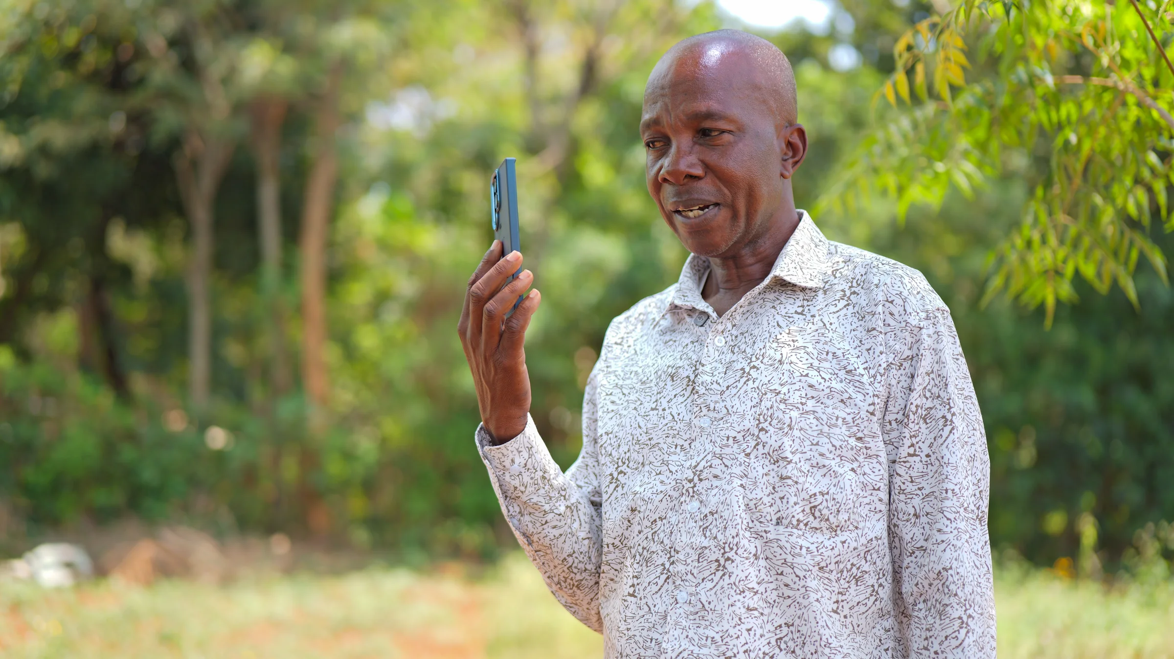 A caller speaking into a mobile phone outdoors
